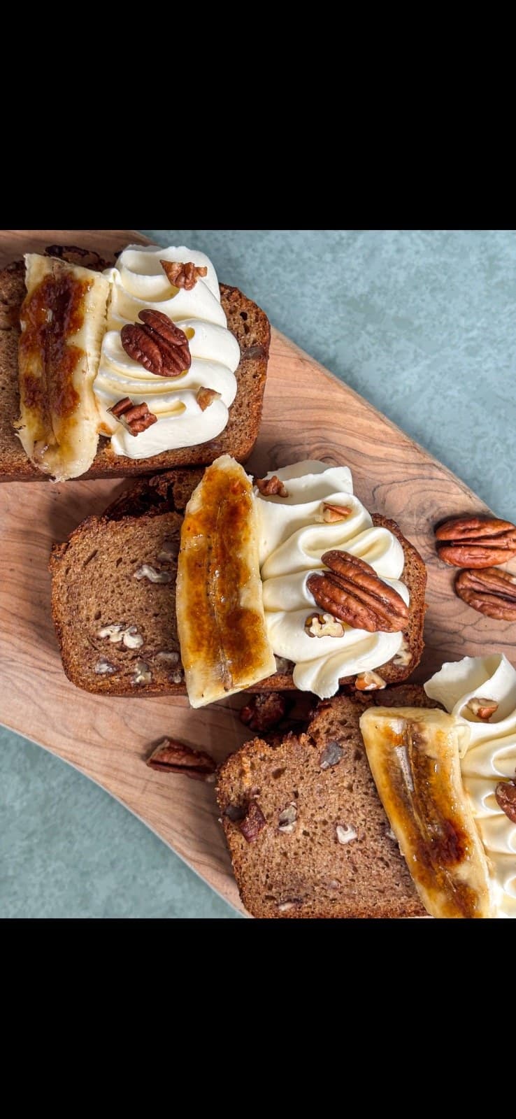 Pastries on a wooden board — a pecan danish and croissants with cream and fruit