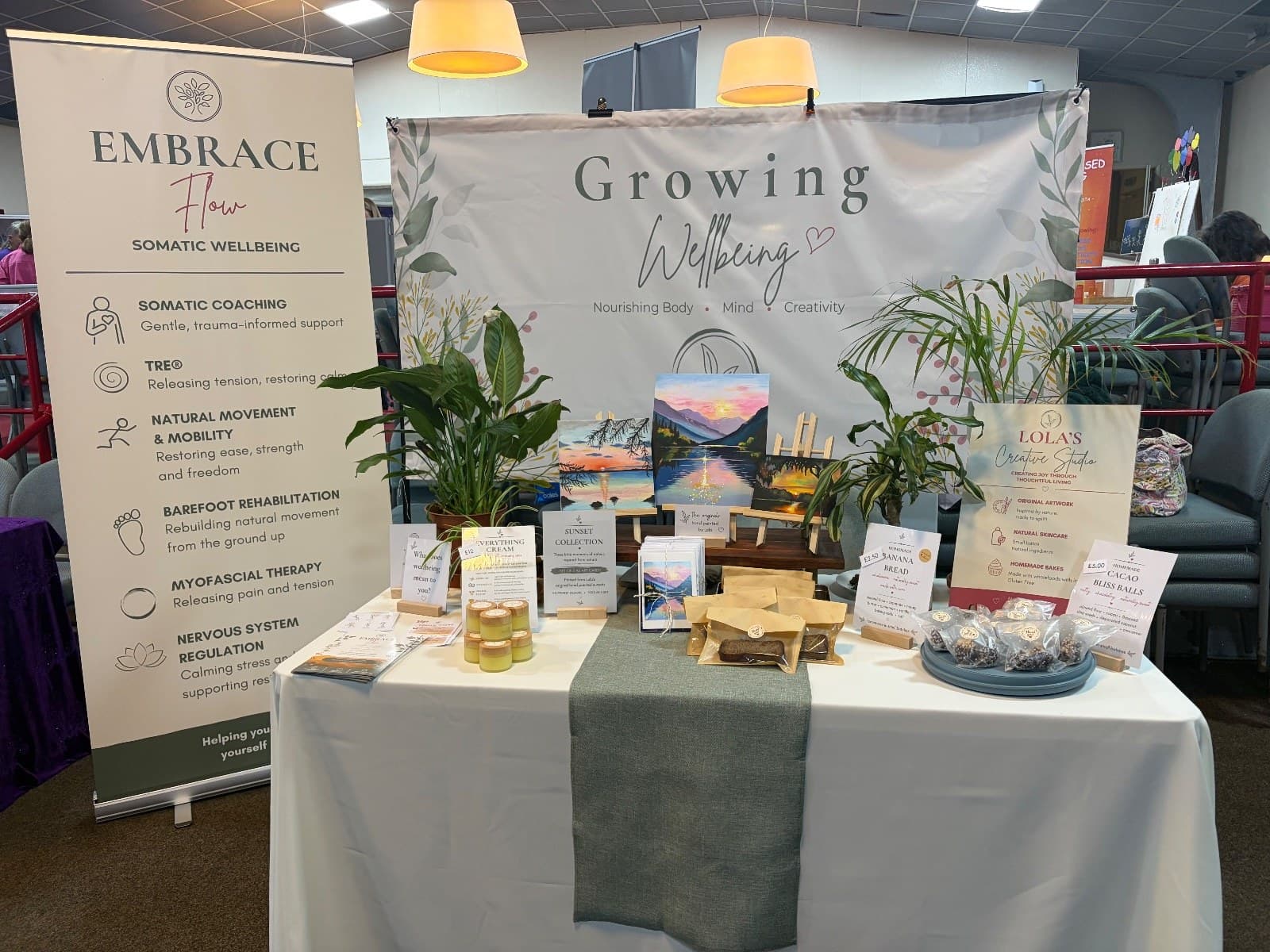 The Growing Wellbeing stall with an Embrace Flow banner, plants and art cards
