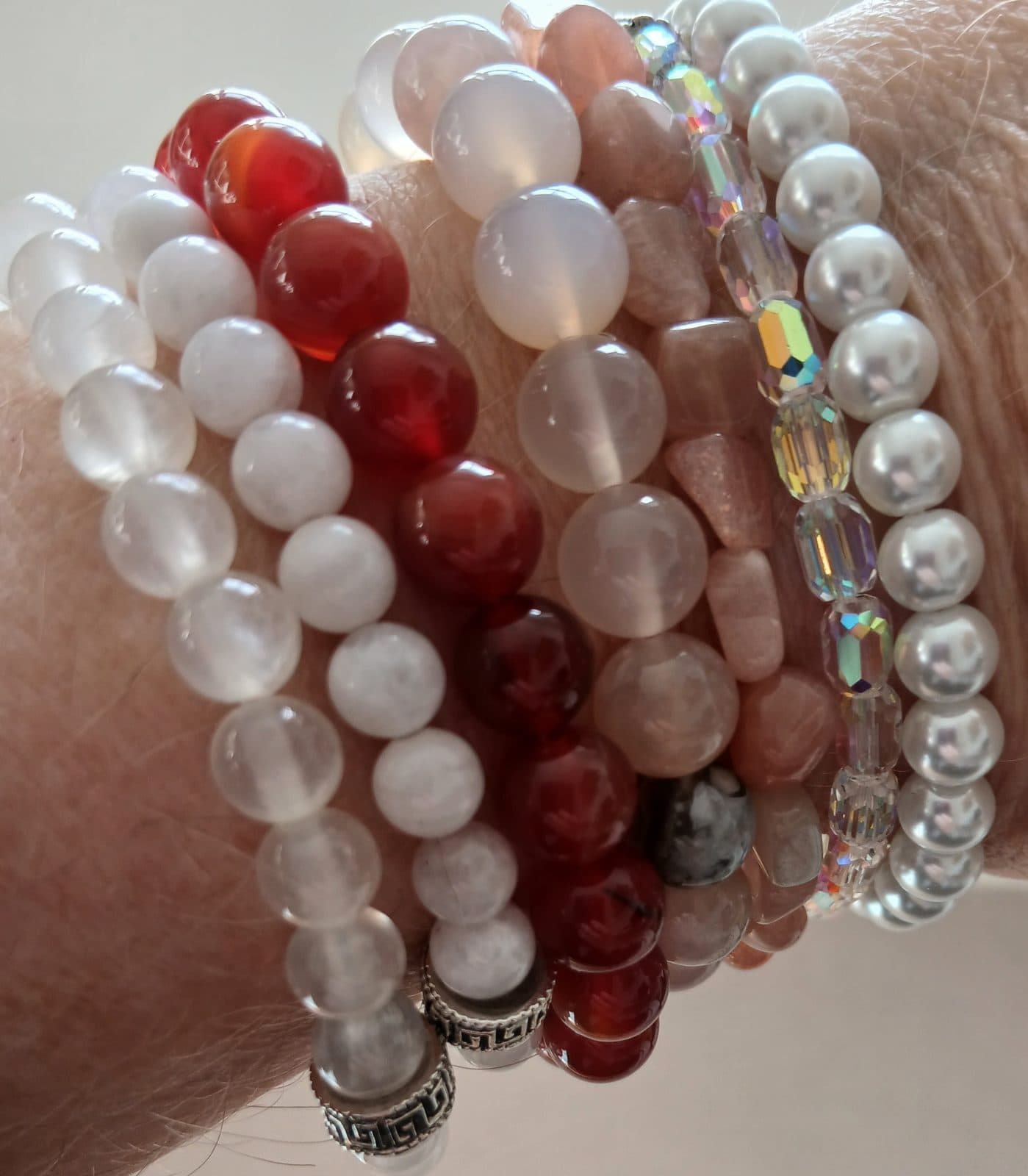 Stacked crystal bracelets in carnelian, moonstone and pearl