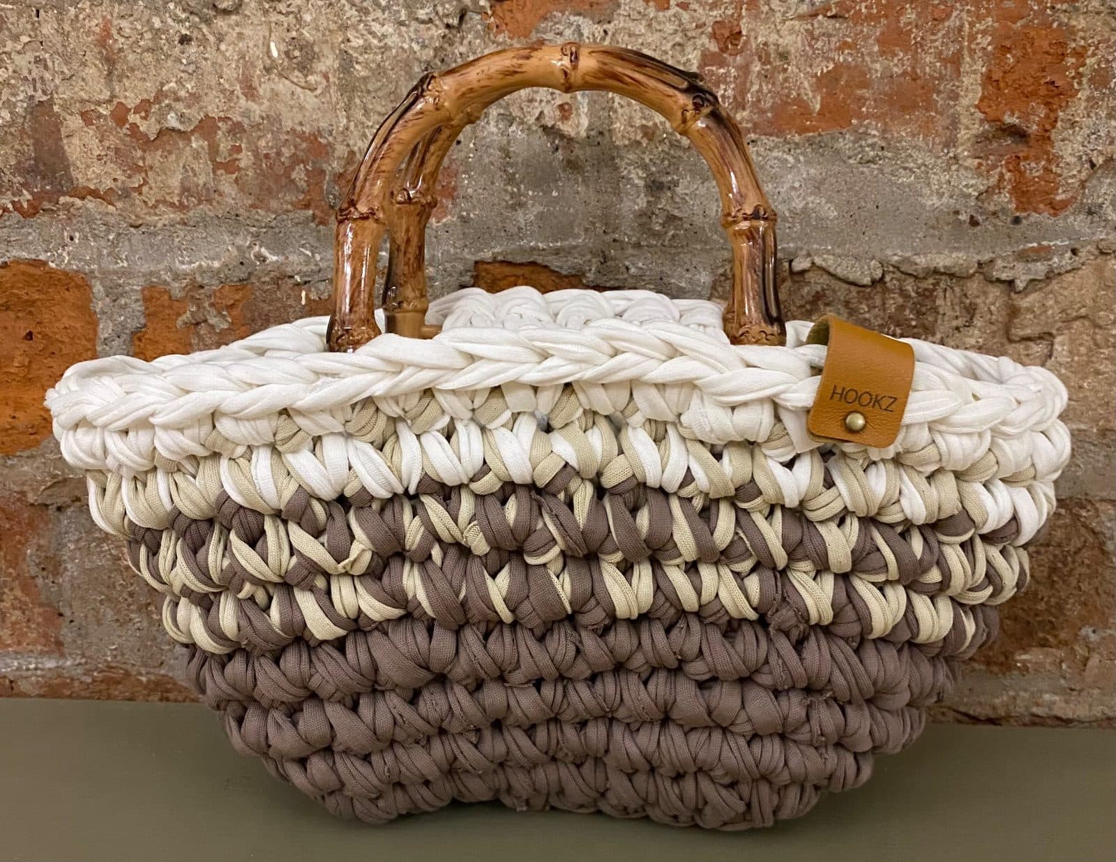 A crochet basket bag in cream and taupe recycled t-shirt yarn