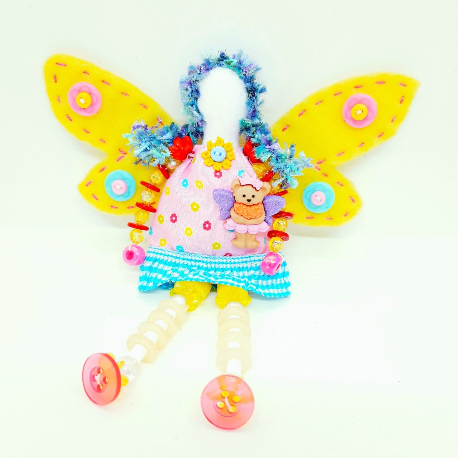 A whimsical button doll with bright yellow wings and beaded legs