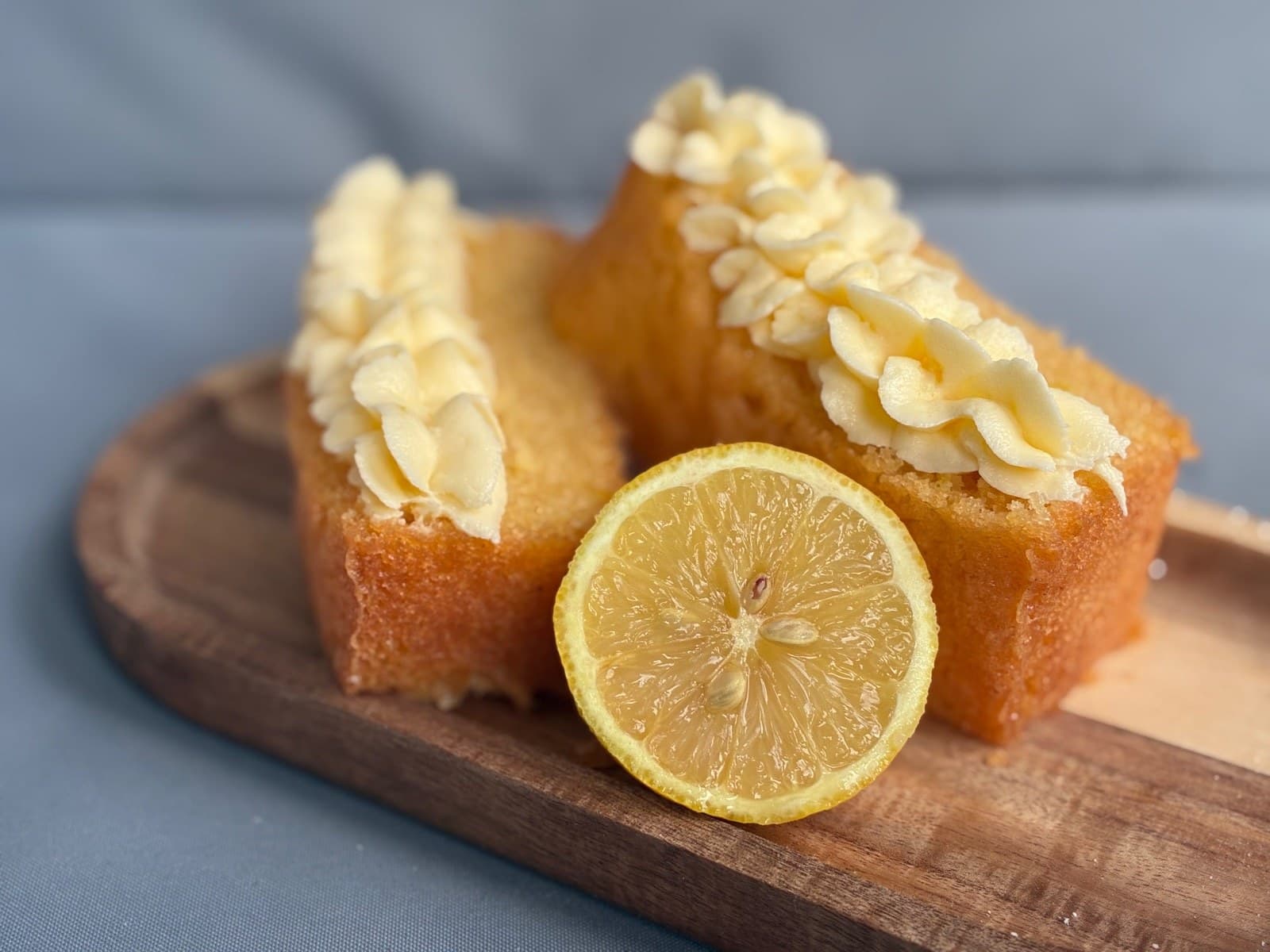 Gluten-free lemon drizzle slices with piped buttercream and fresh lemon