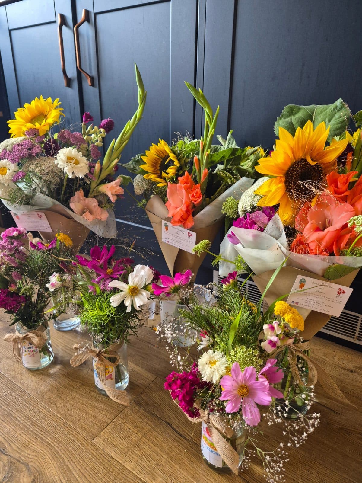 Buckets of just-cut sunflowers and summer flowers wrapped for market