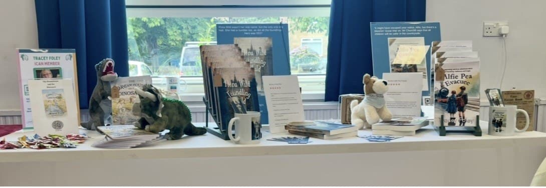 A table of local authors’ books with mugs and display stands